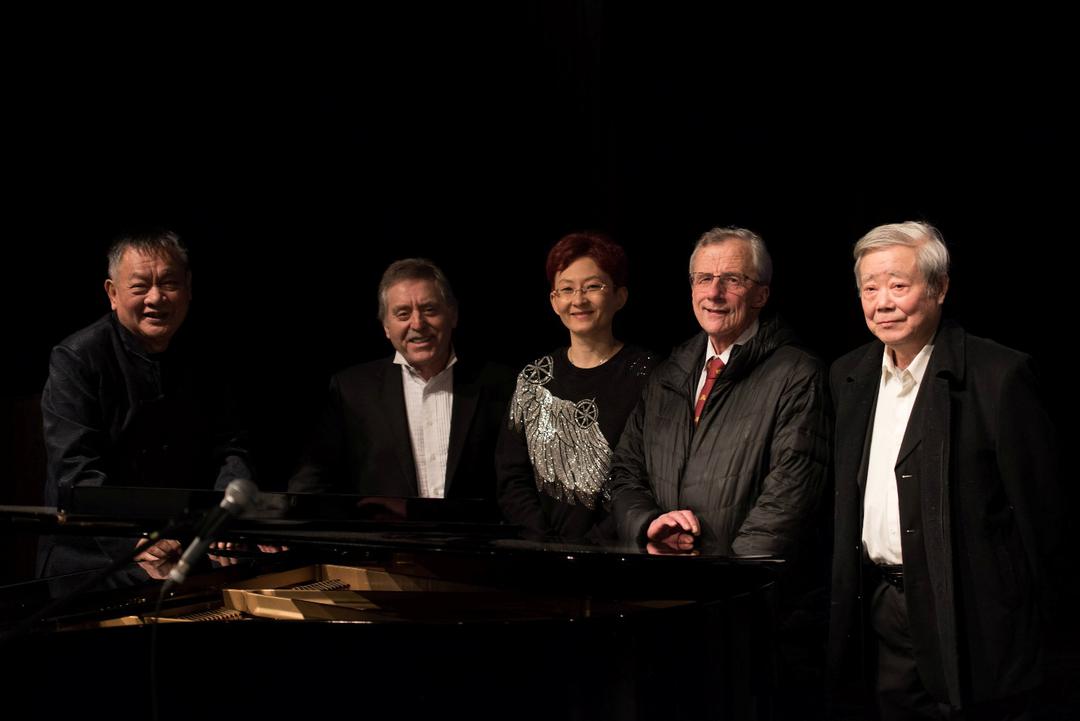 A group of people standing next to a piano

AI-generated content may be incorrect.